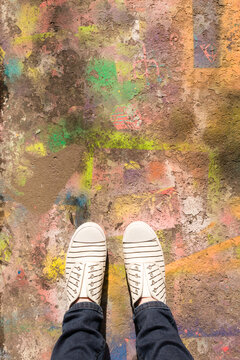 overhead of feet on a spray painted laneway