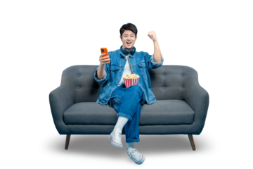 An excited young man with popcorn holds a smartphone and cheers, celebrating a win in a mobile game or seeing great news , PNG