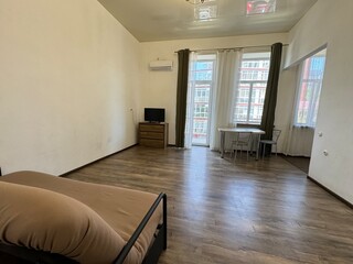 Simple Studio Apartment Interior with Large Window and Wooden Floor
