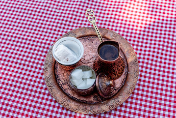 Traditional Turkish coffee brewed in cezve on sand, served in small mug of sweet