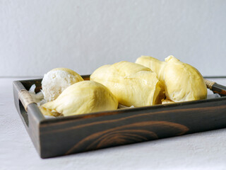 A yellow durian that has been peeled off to reveal the tasty yellow flesh of the durian. Durian fruit on wooden basket
