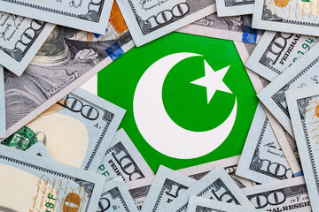 Pakistani flag amidst us dollar bills highlighting economic relations