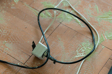 Damaged Electrical Plug and Cord on Red Tile Floor with Debris  Hazardous Home Wiring, Safety...