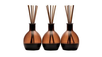 Three aromatic reed diffusers create a calming spa atmosphere with their stylish glass bottles isolated on transparent background