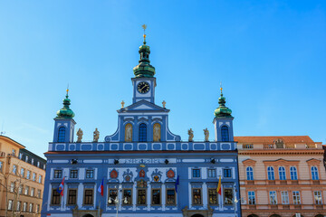 Renaissance-style town hall with clock tower and statues under blue sky