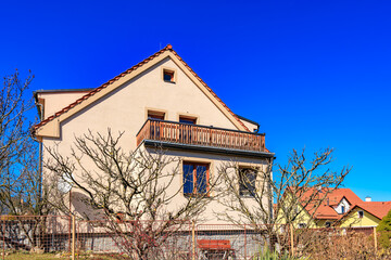 Suburban house with balcony against clear blue sky