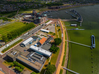 Aerial view of a Dutch harbor with modern residential buildings and green rooftops. Several docks...