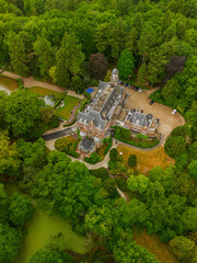 An aerial view of a historic mansion surrounded by lush green trees and a beautifully landscaped...