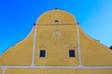 Yellow baroque building facade under clear blue sky