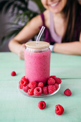 Raspberry Smoothie with Smiling Woman in the Background
