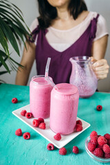 Raspberry Smoothie with a Woman in the Background. Healthy Drink Full of Antioxidants and Vitamins