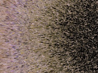 Granular texture made of black and beige specks, resembling sand or digital noise. Abstract wallpaper or texture.