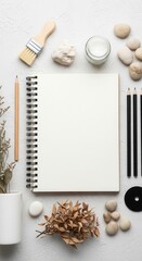 Artistic flat lay with sketchbook pencils brush and natural elements