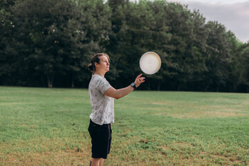 Athletic individual standing on grassy terrain poised to catch frisbee hovering air background with...