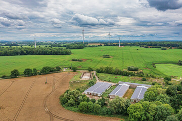 View from above of meadows and fields in Mecklenburg-Western Pomerania with wind turbines in the...