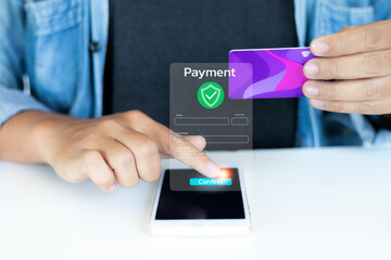 Close-up hand holding a credit card and confirming secure online payment on a mobile phone, concept of digital transaction and e-commerce security.