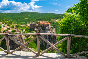 Traditional wooden fence framing view of ancient cliffside monastery in Meteora Greece