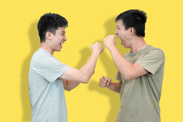 Two young Asian men face each other with clenched fists and open mouths
