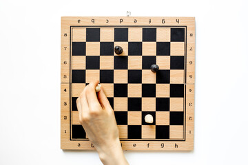 Hand is moving chess piece on chessboard. Game concept