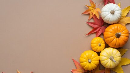 Autumn composition with colorful pumpkins and fall leaves on beige background