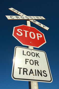 Stop sign - Look for trains against blue sky