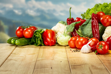 Fresh spring, summer and autumn vegetables on a rustic wooden table with blue sky in the background – healthy seasonal food and natural lifestyle concept.