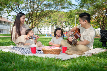 Young family spending quality time outdoors with music and play on a sunny day.