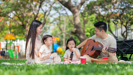 Young family spending quality time outdoors with music and play on a sunny day.