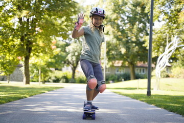 a girl skateboarding in the park with a helmet on