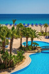 Naklejka premium Enjoy a beautiful beach scene with a swimming pool and a clear sky.