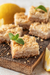 Lemon crumble bars close up on wooden cutting board, oatmeal lemon bars