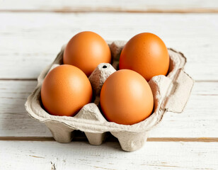 Brown chicken eggs in cardboard tray on wooden table background
