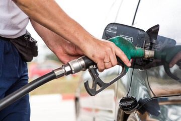 Gas station. A gas station attendant in a car's fuel tank. A man refuels a car with gasoline....