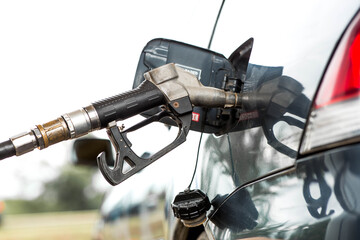 Gas station. Refueling a car with gasoline. Fuel dispenser in the car's fuel tank at a gas station. Rising fuel prices worldwide.