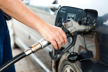 Gas station. A gas station attendant in a car's fuel tank. A man refuels a car with gasoline....