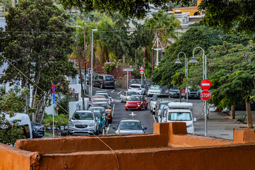 Colourful cars drive along a road on the island of Tenerife on a summer evening	
