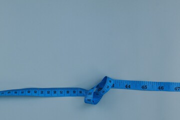 Blue measuring tape isolated on blue background. diet for weight loss concept.