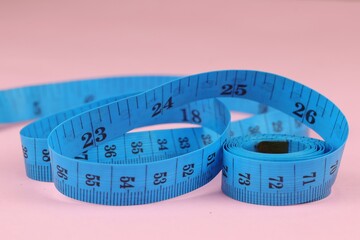 Blue measuring tape isolated on pink background. diet for weight loss concept.