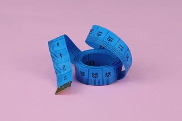 Blue measuring tape isolated on pink background. diet for weight loss concept.