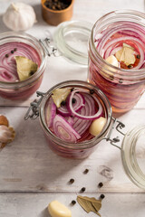 Homemade pickled red onions in jars, bright background