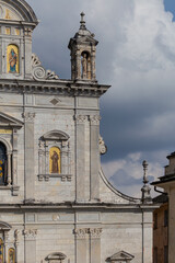 Facade of a Historic European Church Featuring Ornate Stonework and Religious Frescoes
