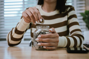 A woman holds a piggy bank, which symbolizes savings, financial planning, and economic challenges....