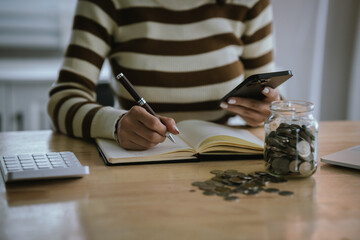A woman holds a piggy bank, which symbolizes savings, financial planning, and economic challenges....