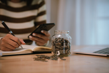 A woman holds a piggy bank, which symbolizes savings, financial planning, and economic challenges....