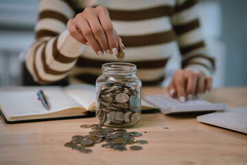 A woman holds a piggy bank, which symbolizes savings, financial planning, and economic challenges....