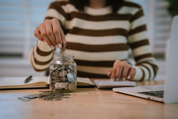 A woman holds a piggy bank, which symbolizes savings, financial planning, and economic challenges....