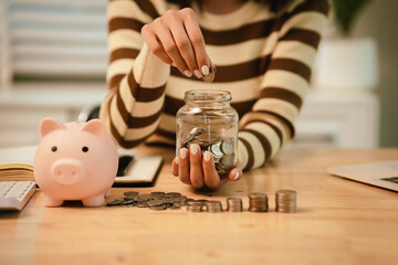 A woman holds a piggy bank, which symbolizes savings, financial planning, and economic challenges....