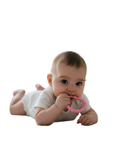 A baby in a white onesie is lying down while holding a pink teething ring in its mouth, isolated on transparent background