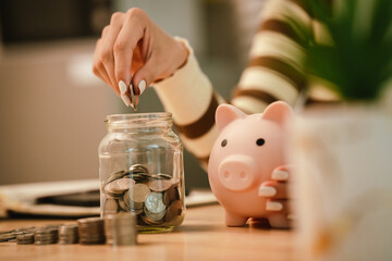 A woman holds a piggy bank, which symbolizes savings, financial planning, and economic challenges....