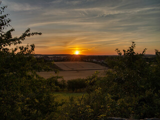 Peaceful sunrise over farmland and a village in Saxony-Anhalt, Germany. Soft morning light, golden...